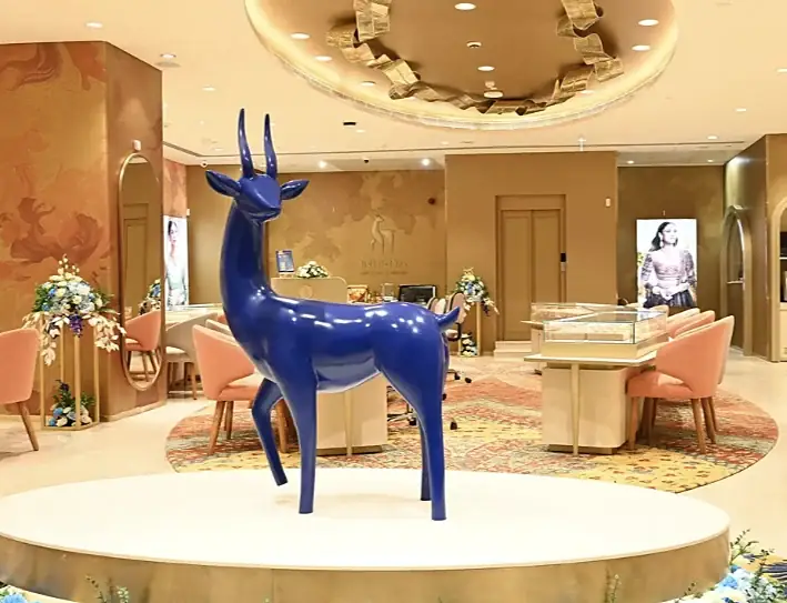 Blue deer sculpture in the peach-toned interior of Indriya Andheri West
