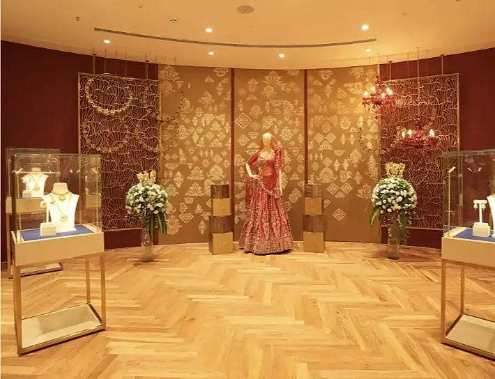 Bridal room at Indriya Borivali with a red lehenga and necklace displays before a gold lattice wall