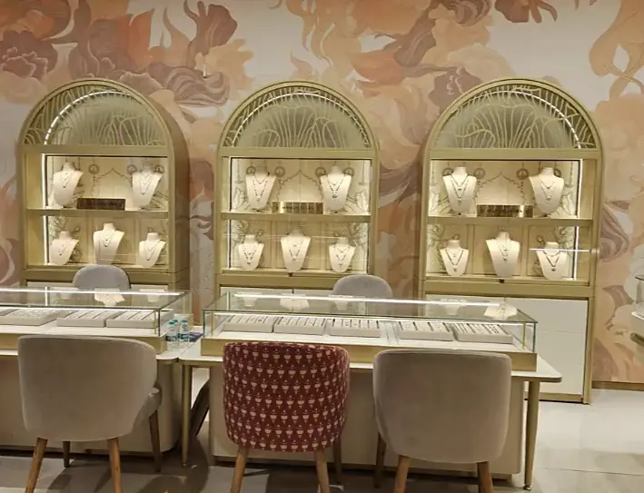 Arched gold display cabinets against a floral mural at Indriya Phoenix Marketcity