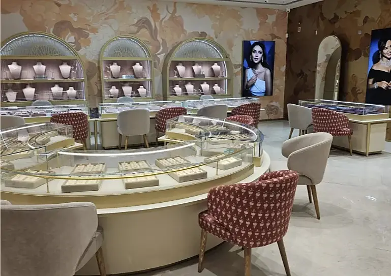 Curved glass jewellery counter with patterned chairs at Indriya Phoenix Marketcity